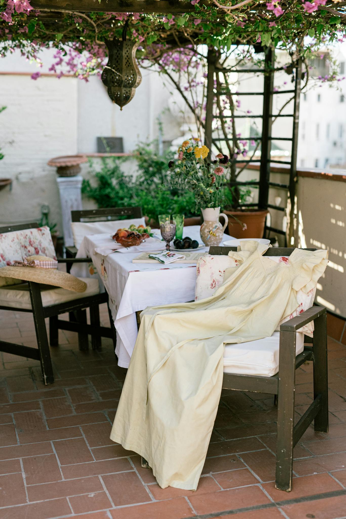 Beautifully set patio table under flowers, ideal for summer dining.