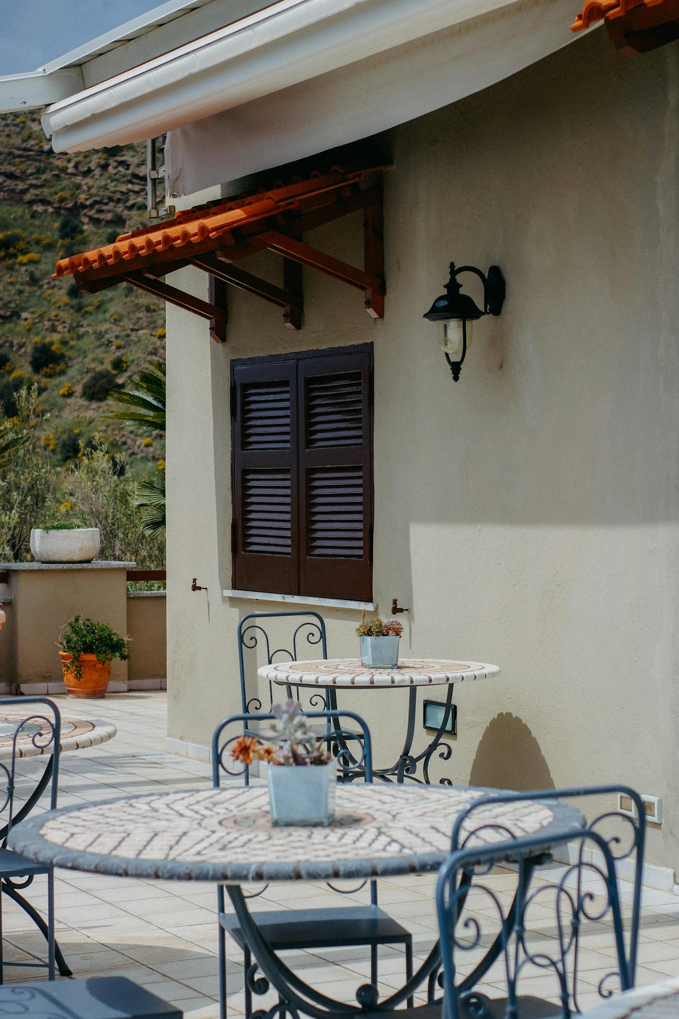 Serene outdoor patio with elegant metal chairs and tables under clear skies.